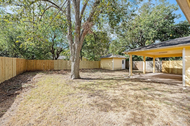 view of yard featuring a patio, a fenced backyard, and an outdoor structure