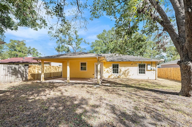 back of property with a fenced backyard and a patio area