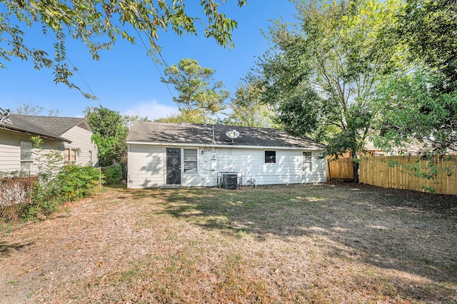 back of house with a yard and central air condition unit