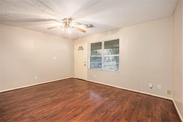 empty room with ceiling fan, a textured ceiling, and dark hardwood / wood-style floors