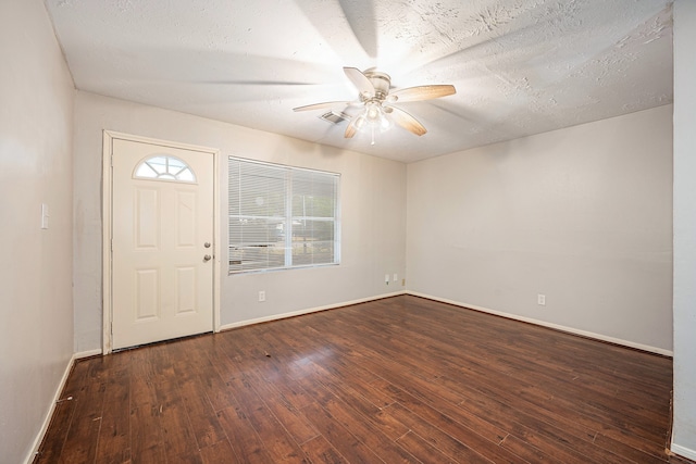 foyer entrance with ceiling fan, a textured ceiling, plenty of natural light, and dark hardwood / wood-style floors