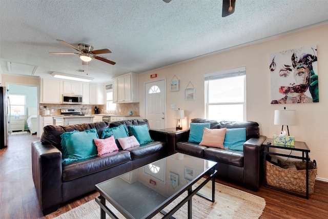 living room with a textured ceiling, dark wood-type flooring, and ceiling fan