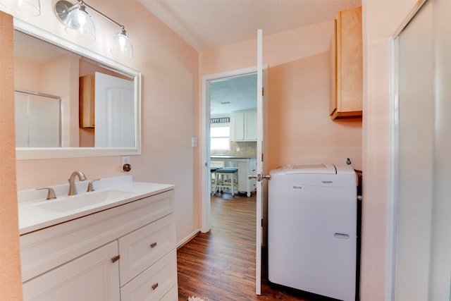 bathroom featuring vanity, washer / clothes dryer, a textured ceiling, and wood-type flooring