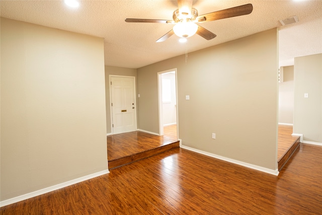 empty room featuring a textured ceiling, wood-type flooring, and ceiling fan