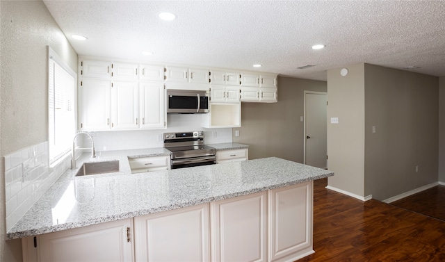 kitchen featuring appliances with stainless steel finishes, white cabinetry, and light stone counters