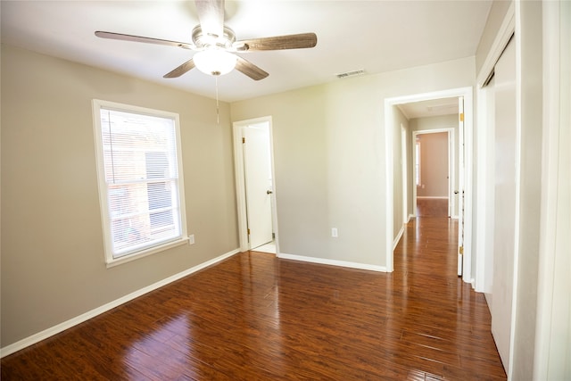 spare room featuring dark wood-type flooring and ceiling fan