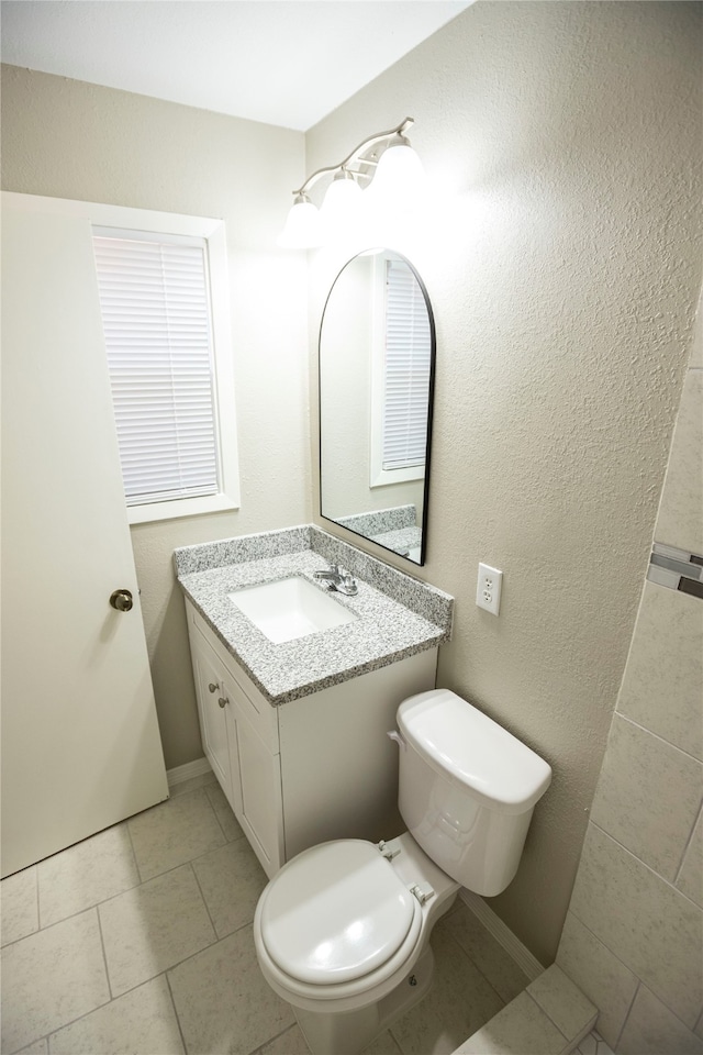 bathroom with vanity, toilet, and tile patterned flooring