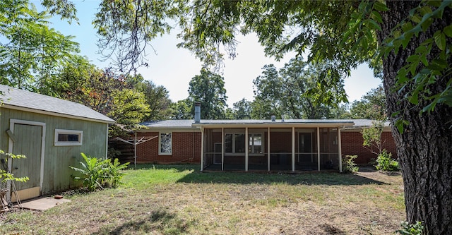 rear view of property with a sunroom and a lawn