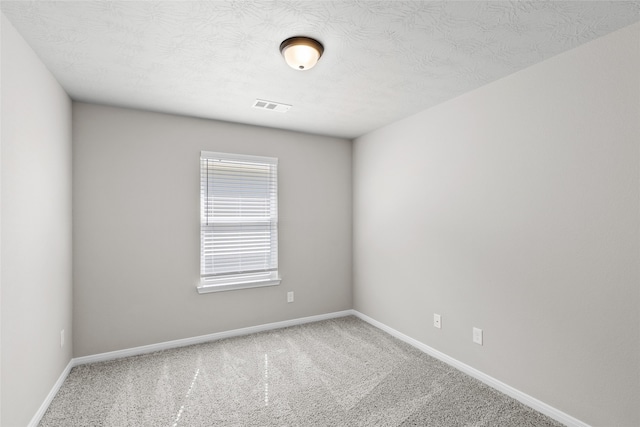 carpeted spare room featuring a textured ceiling