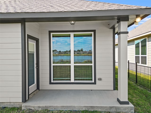 view of exterior entry featuring a water view and covered porch