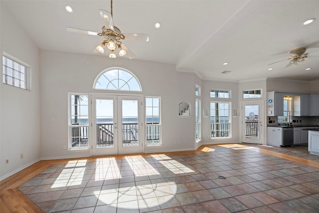 unfurnished living room featuring french doors, ornamental molding, hardwood / wood-style floors, sink, and ceiling fan