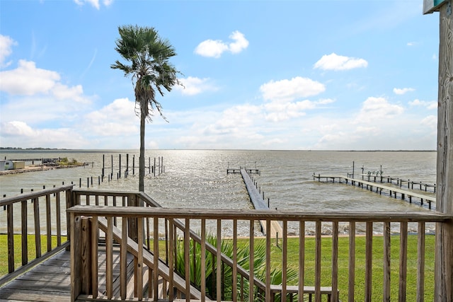 dock area with a yard and a water view