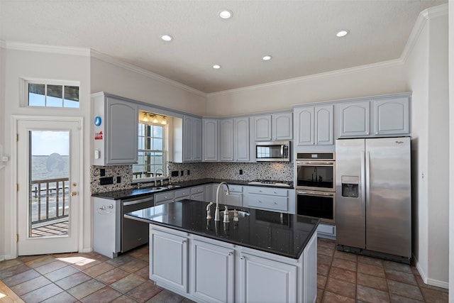 kitchen featuring sink, a center island, decorative backsplash, and stainless steel appliances