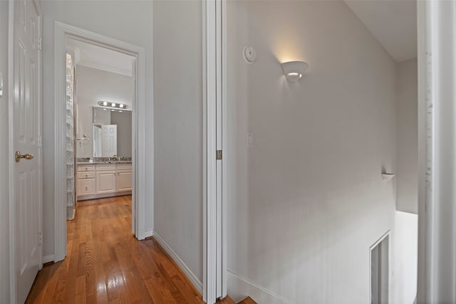 hall featuring light hardwood / wood-style flooring and crown molding