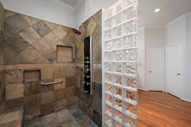 bathroom featuring tiled shower, hardwood / wood-style floors, and crown molding