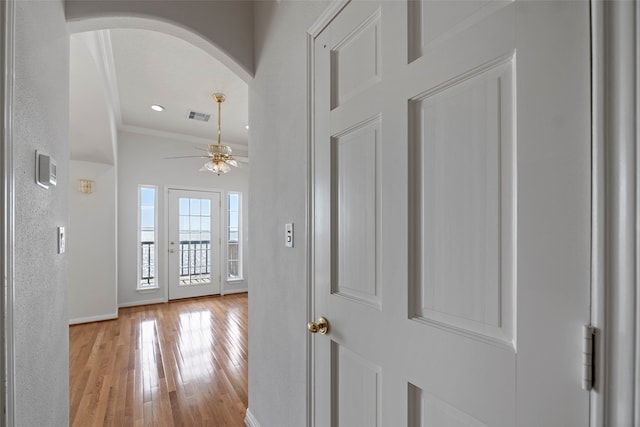 hallway with crown molding and light wood-type flooring