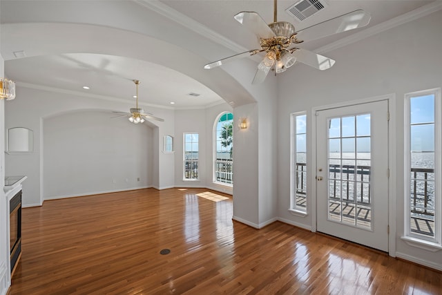 interior space featuring a water view, ornamental molding, hardwood / wood-style flooring, and plenty of natural light