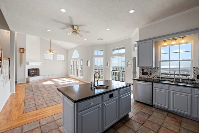 kitchen featuring dishwasher, a kitchen island with sink, sink, and a healthy amount of sunlight