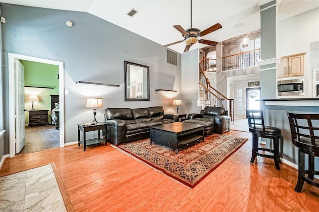 living room featuring ceiling fan, high vaulted ceiling, and hardwood / wood-style flooring