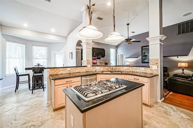 kitchen featuring decorative columns, decorative light fixtures, vaulted ceiling, light brown cabinetry, and appliances with stainless steel finishes