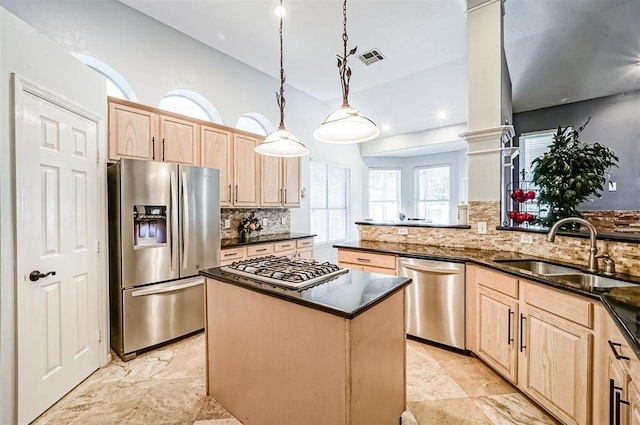 kitchen with appliances with stainless steel finishes, pendant lighting, light brown cabinetry, and sink