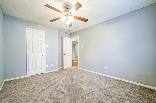 unfurnished bedroom featuring carpet, a textured ceiling, and ceiling fan