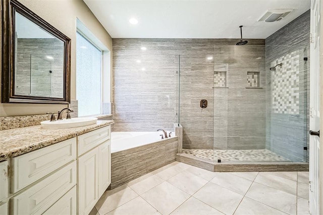 bathroom featuring tile patterned flooring, vanity, and plus walk in shower