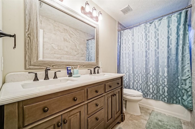 full bathroom with vanity, tile patterned flooring, toilet, shower / bath combo with shower curtain, and a textured ceiling