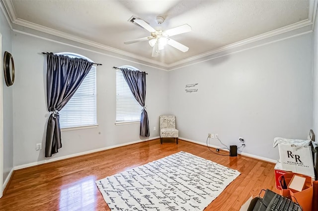 living area with hardwood / wood-style flooring, ceiling fan, and crown molding