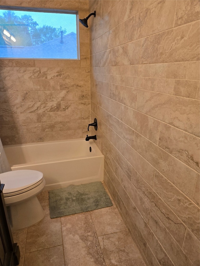 bathroom with tiled shower / bath combo and toilet