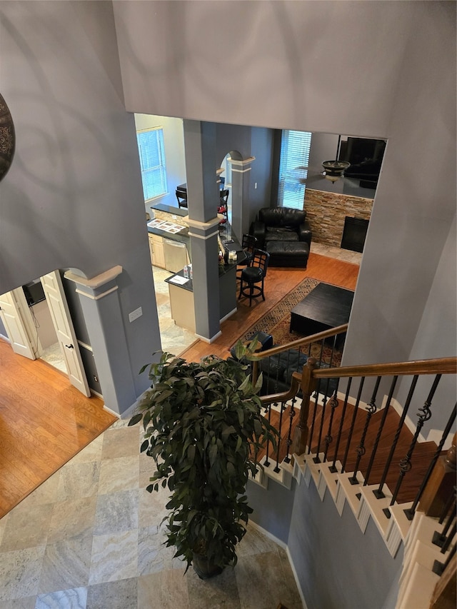 stairs featuring a stone fireplace and wood-type flooring