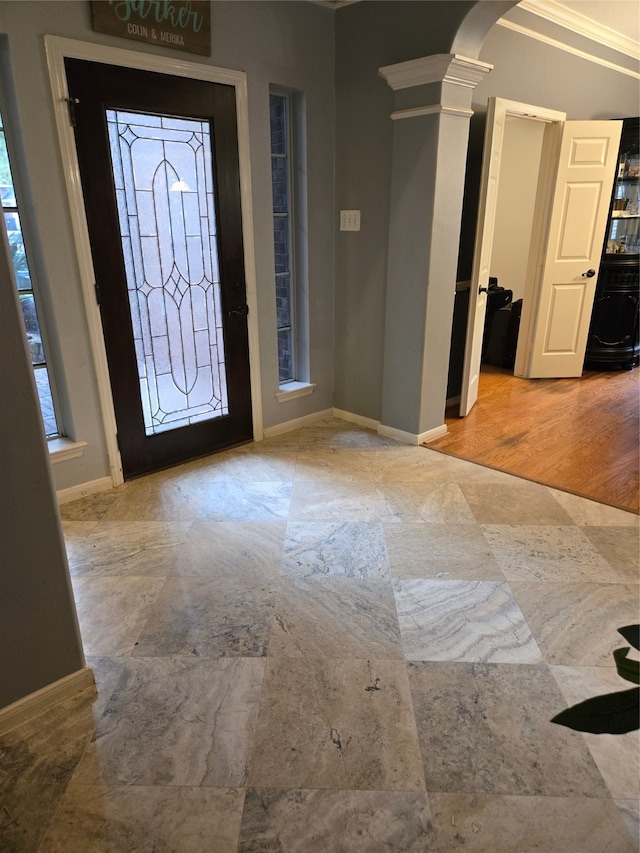 foyer featuring light hardwood / wood-style floors, decorative columns, and ornamental molding