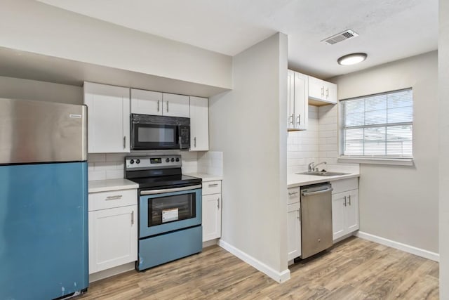 13210 Rockglen St, Houston, TX 77015 - kitchen with appliances with stainless steel finishes, backsplash, light countertops, light wood-type flooring, and white cabinets