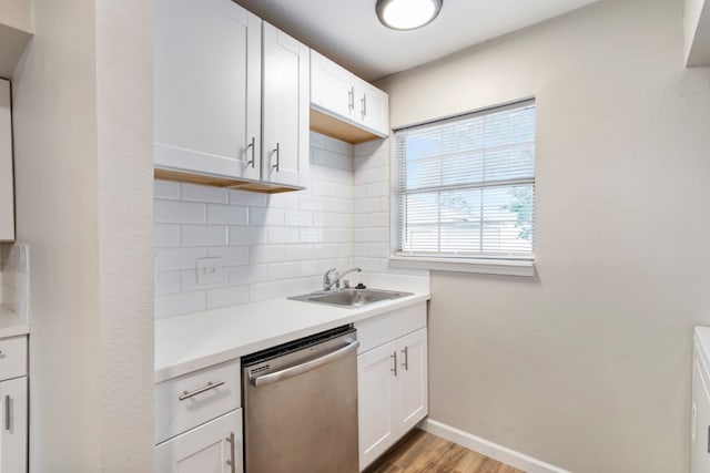 kitchen with decorative backsplash, dishwasher, light hardwood / wood-style flooring, sink, and white cabinetry