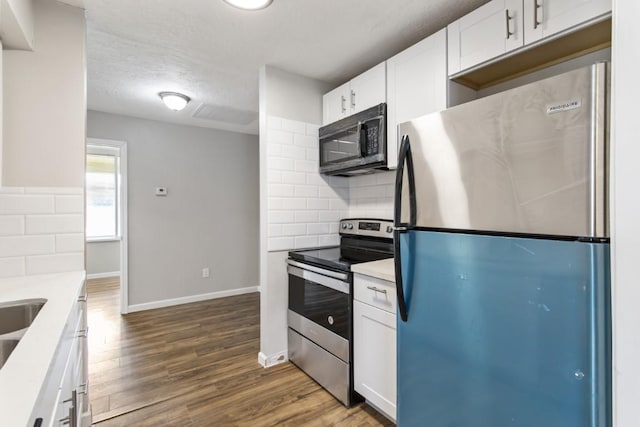13210 Rockglen St, Houston, TX 77015 - kitchen with appliances with stainless steel finishes, tasteful backsplash, white cabinets, dark wood-style flooring, and light countertops