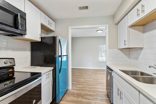 kitchen featuring backsplash, sink, appliances with stainless steel finishes, and white cabinetry