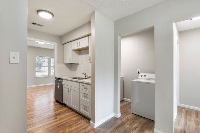 kitchen featuring dark hardwood / wood-style flooring, sink, dishwasher, and washer / clothes dryer