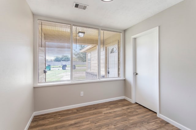 unfurnished room with dark wood-type flooring