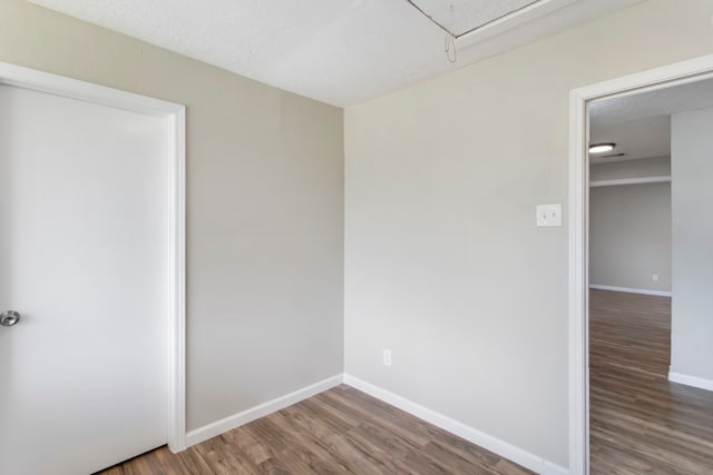 empty room with a textured ceiling and hardwood / wood-style flooring