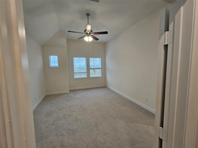 carpeted spare room featuring ceiling fan and lofted ceiling