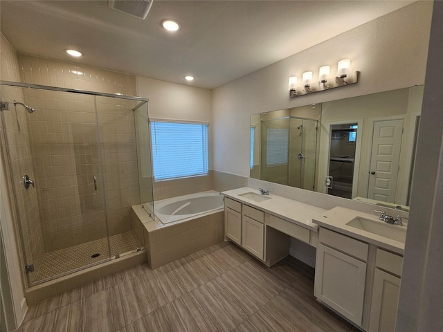 bathroom featuring vanity and independent shower and bath