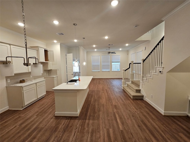 kitchen with ceiling fan, sink, hanging light fixtures, and dark wood-type flooring