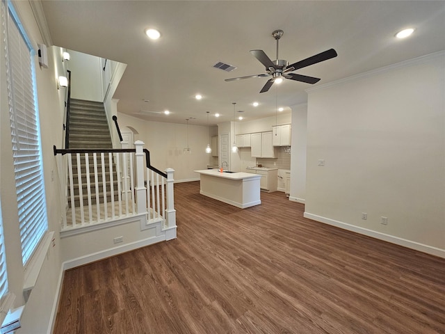 unfurnished living room with dark hardwood / wood-style floors, ceiling fan, sink, and crown molding