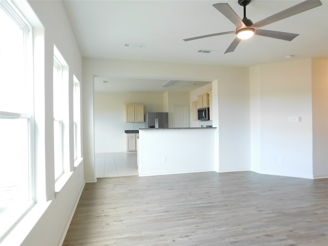 unfurnished living room featuring light hardwood / wood-style floors, a healthy amount of sunlight, and ceiling fan