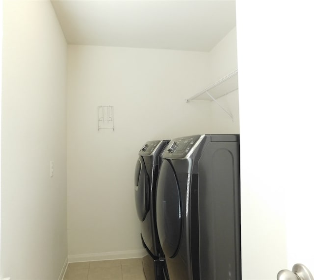 laundry room with independent washer and dryer and light tile patterned floors