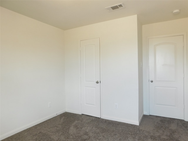 unfurnished bedroom with dark carpet