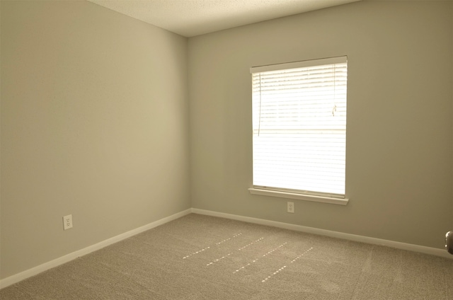 carpeted spare room featuring a textured ceiling