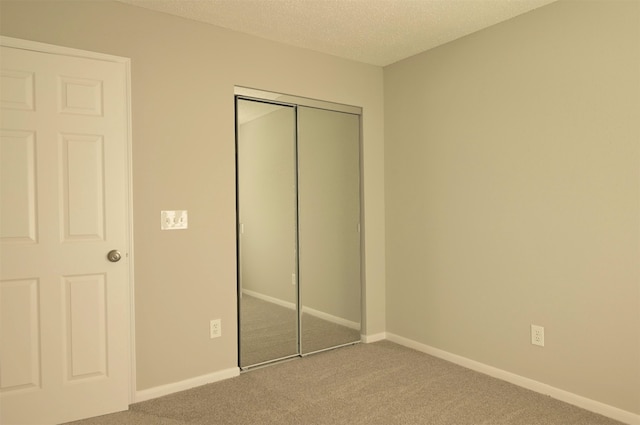 unfurnished bedroom with a closet, carpet flooring, and a textured ceiling