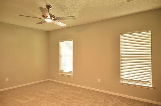 spare room featuring ceiling fan, a textured ceiling, and light colored carpet