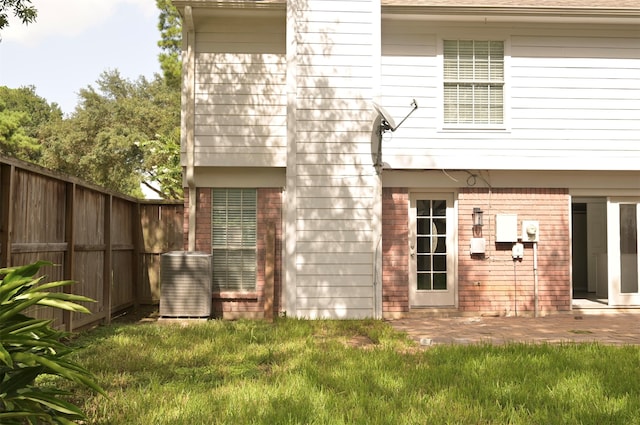 rear view of property with a patio area, a lawn, and central AC unit